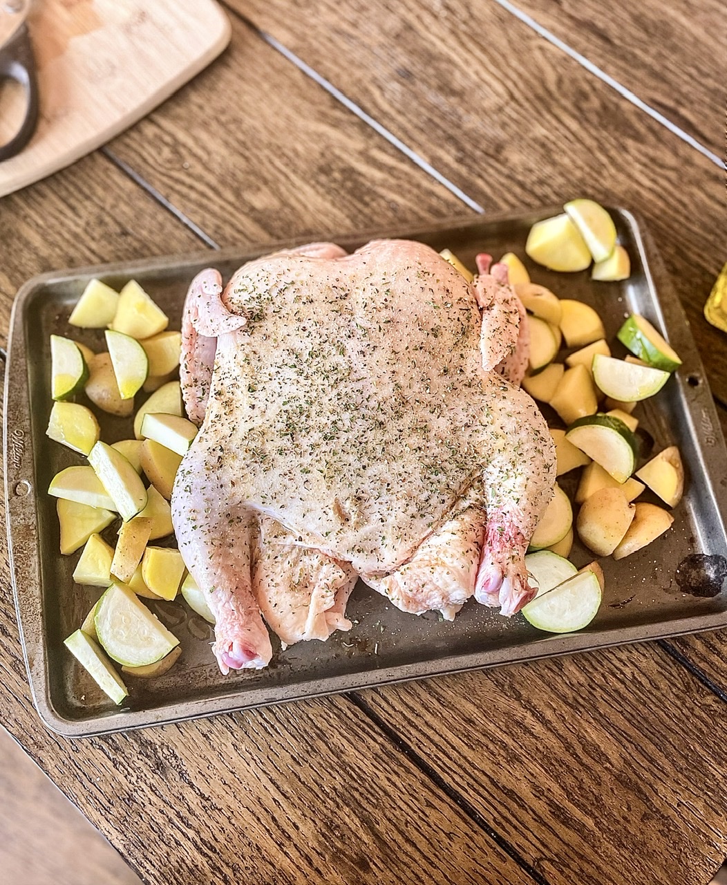 raw chicken on cooking sheet with vegetables