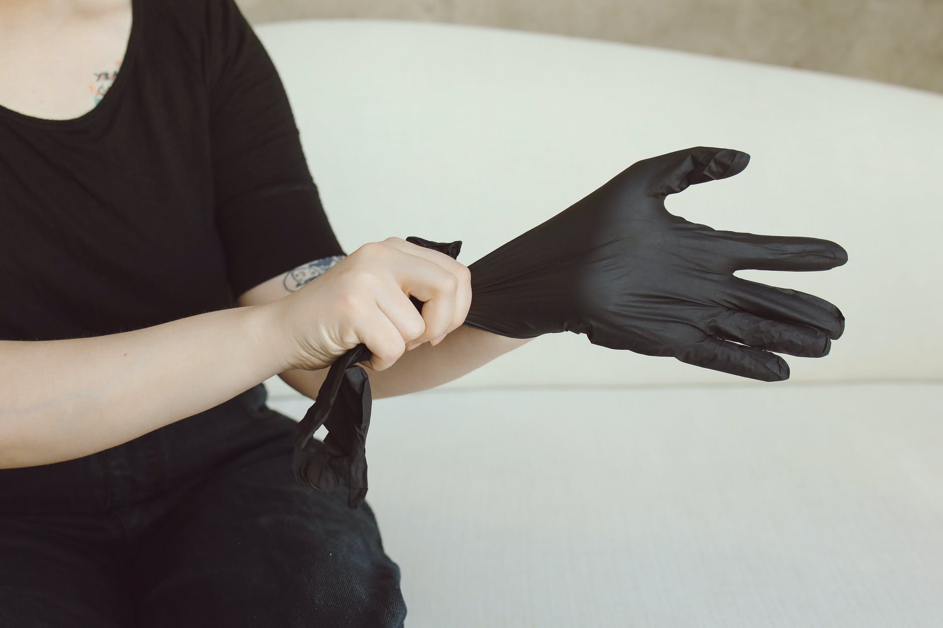 person wearing a black disposable glove