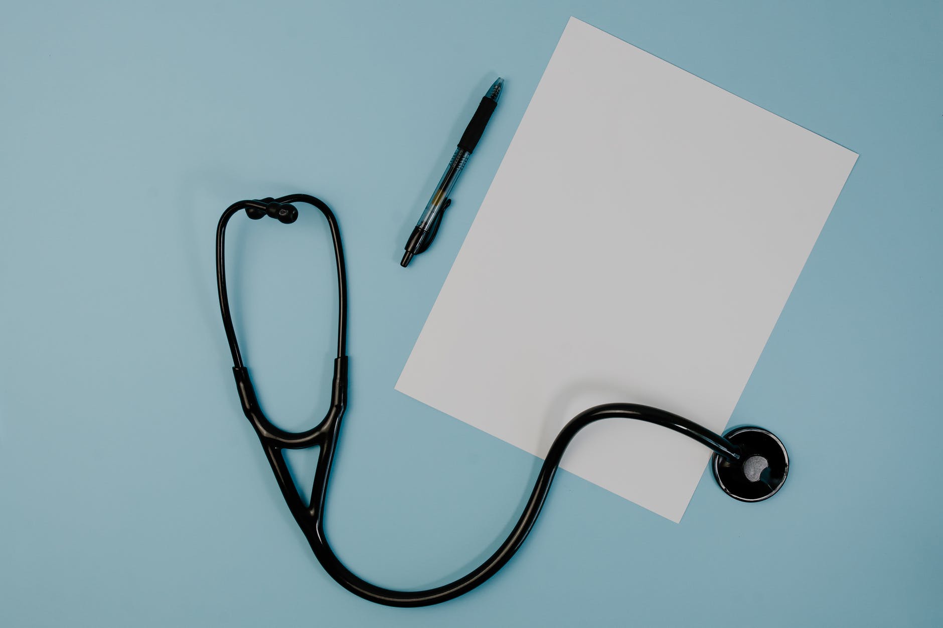 black stethoscope near the blank paper